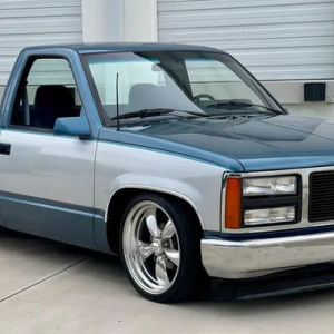 a blue truck parked in front of a garage door